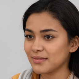 Joyful latino young-adult female with long  brown hair and brown eyes