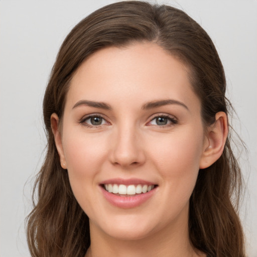 Joyful white young-adult female with long  brown hair and grey eyes