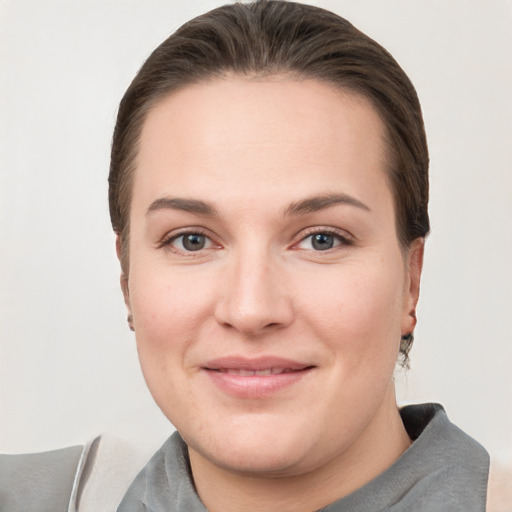 Joyful white young-adult female with short  brown hair and grey eyes