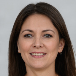 Joyful white adult female with long  brown hair and grey eyes