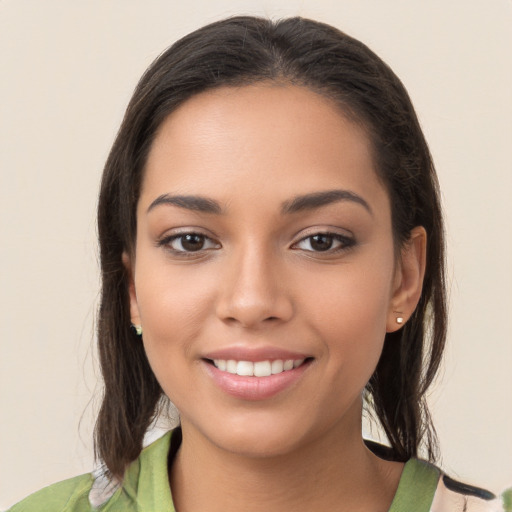 Joyful latino young-adult female with long  brown hair and brown eyes