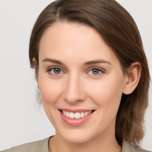 Joyful white young-adult female with medium  brown hair and grey eyes