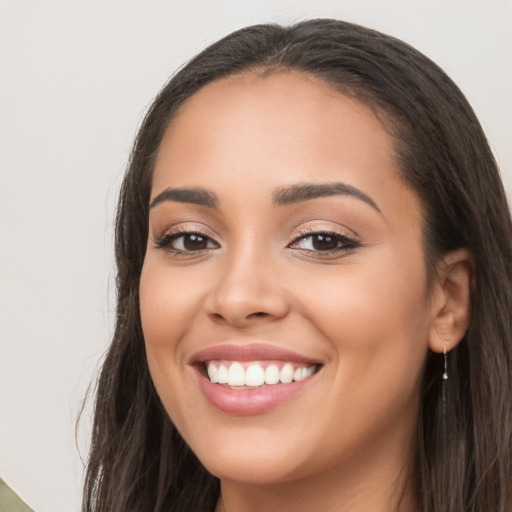 Joyful latino young-adult female with long  brown hair and brown eyes