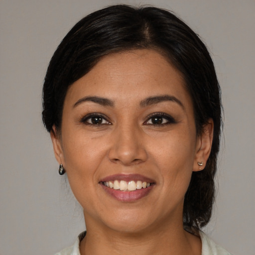 Joyful latino adult female with medium  black hair and brown eyes