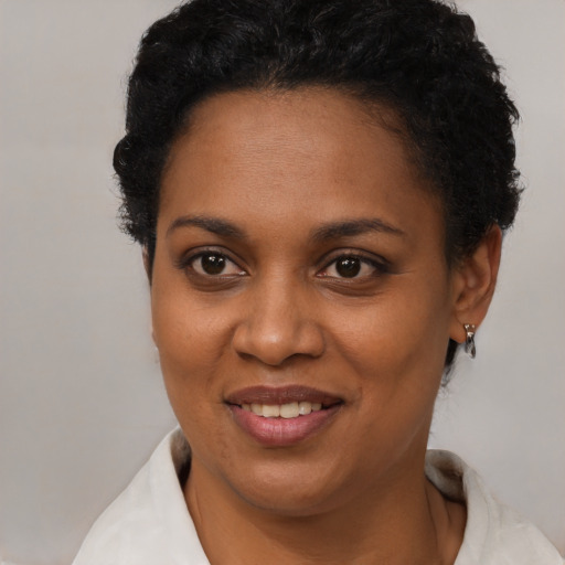 Joyful black young-adult female with short  brown hair and brown eyes
