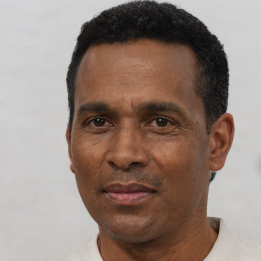Joyful black adult male with short  black hair and brown eyes