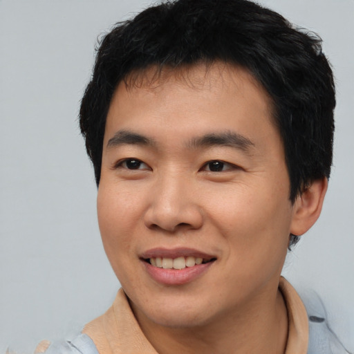 Joyful asian young-adult male with short  brown hair and brown eyes
