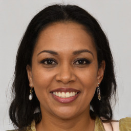 Joyful black adult female with long  brown hair and brown eyes