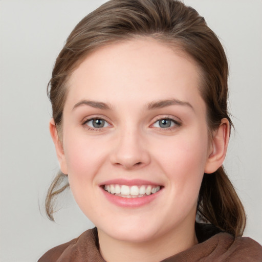 Joyful white young-adult female with medium  brown hair and blue eyes