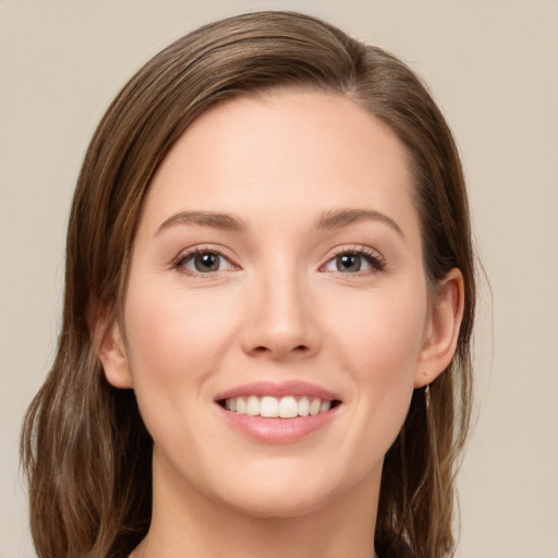 Joyful white young-adult female with long  brown hair and green eyes