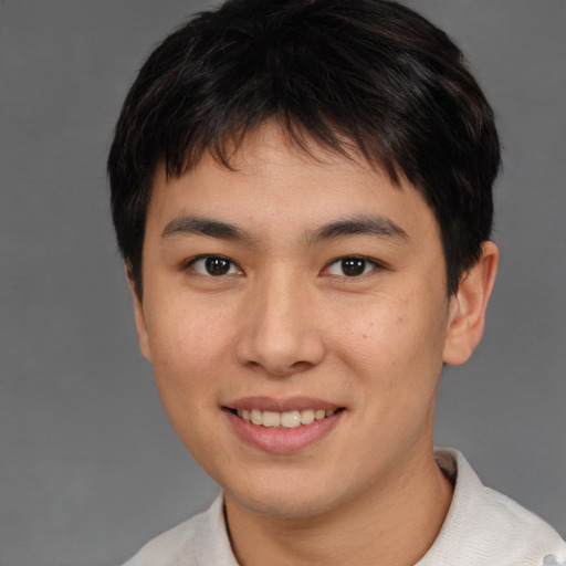 Joyful asian young-adult male with short  brown hair and brown eyes