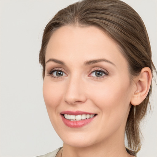 Joyful white young-adult female with medium  brown hair and grey eyes