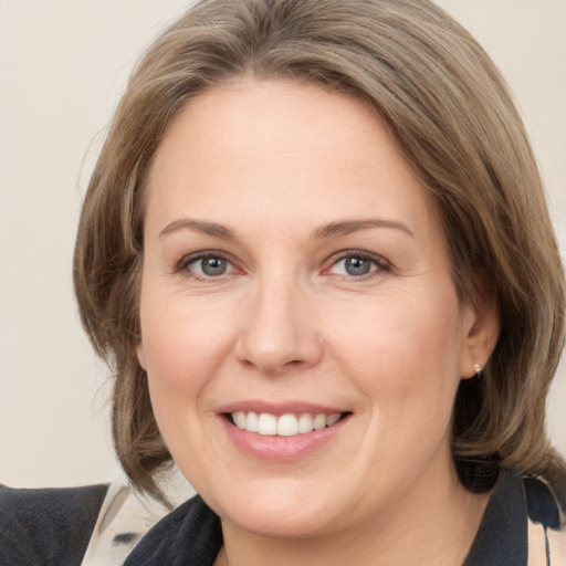 Joyful white adult female with medium  brown hair and grey eyes