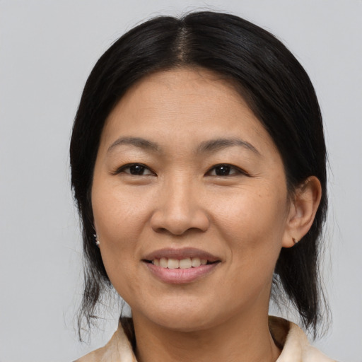 Joyful asian adult female with medium  black hair and brown eyes