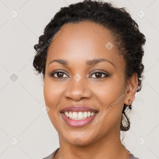 Joyful black young-adult female with long  brown hair and brown eyes