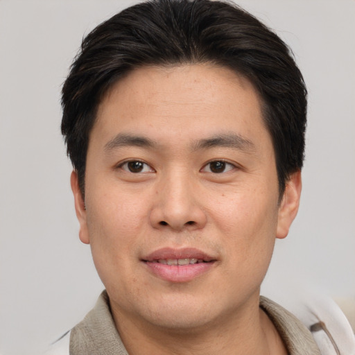Joyful white young-adult male with short  brown hair and brown eyes