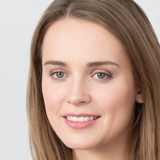 Joyful white young-adult female with long  brown hair and grey eyes