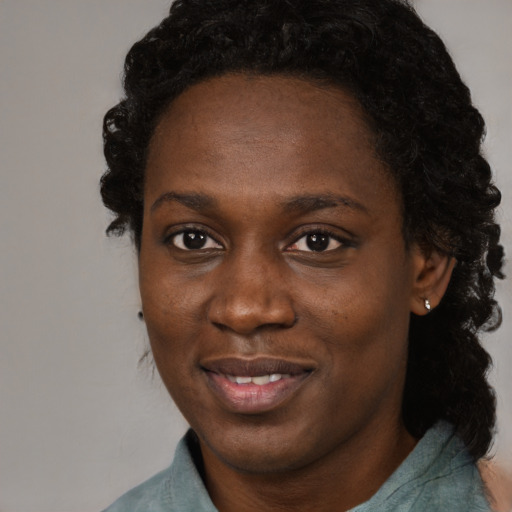 Joyful black young-adult female with long  brown hair and brown eyes