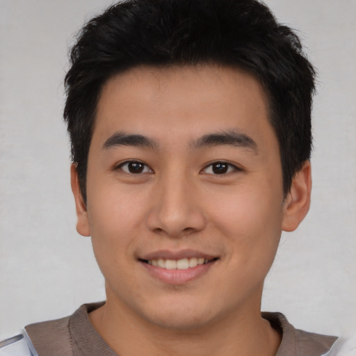 Joyful asian young-adult male with short  brown hair and brown eyes