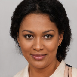 Joyful black adult female with medium  brown hair and brown eyes