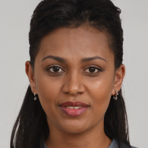 Joyful black young-adult female with long  brown hair and brown eyes