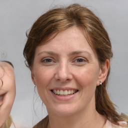 Joyful white adult female with medium  brown hair and grey eyes