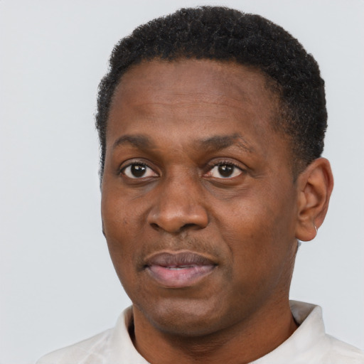 Joyful black adult male with short  black hair and brown eyes
