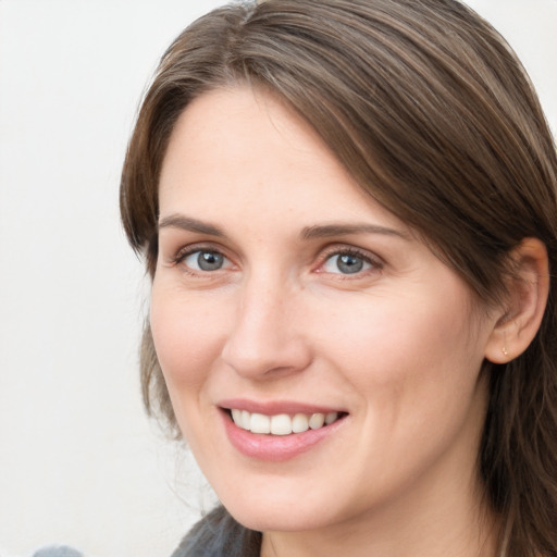 Joyful white young-adult female with medium  brown hair and grey eyes