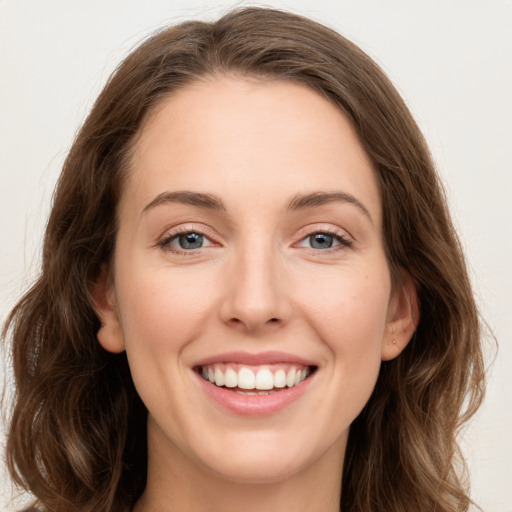 Joyful white young-adult female with long  brown hair and green eyes