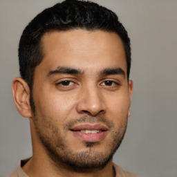 Joyful latino young-adult male with short  brown hair and brown eyes