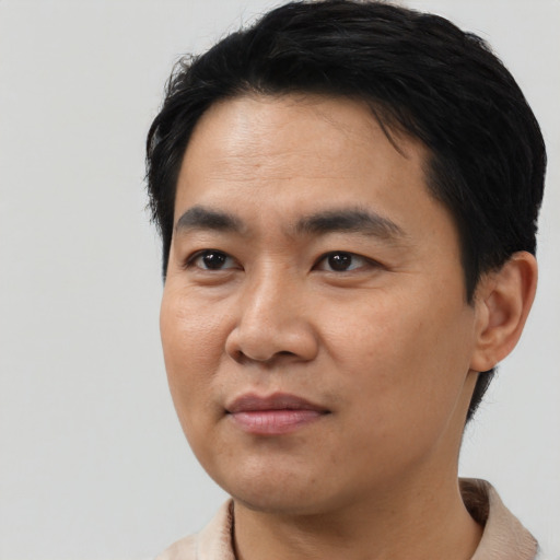 Joyful asian young-adult male with short  black hair and brown eyes
