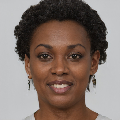 Joyful black young-adult female with short  black hair and brown eyes