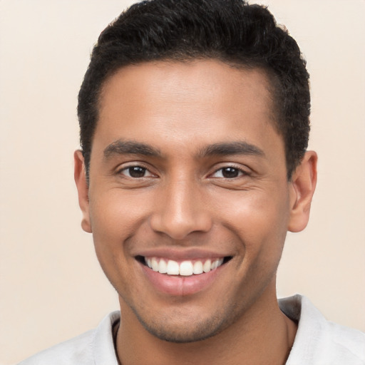 Joyful latino young-adult male with short  brown hair and brown eyes