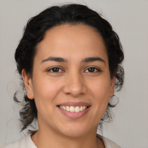 Joyful latino young-adult female with medium  brown hair and brown eyes