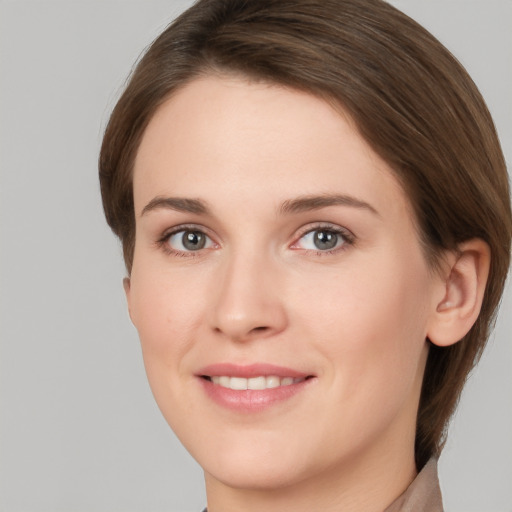 Joyful white young-adult female with medium  brown hair and grey eyes