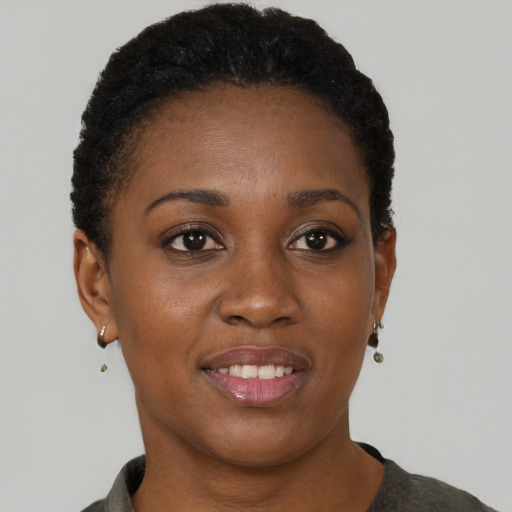 Joyful black young-adult female with short  brown hair and brown eyes