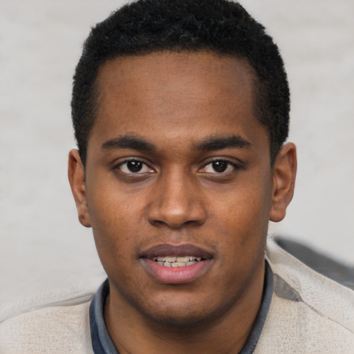 Joyful black young-adult male with short  brown hair and brown eyes