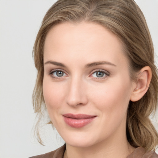 Joyful white young-adult female with medium  brown hair and blue eyes