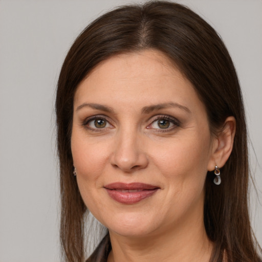 Joyful white adult female with long  brown hair and grey eyes