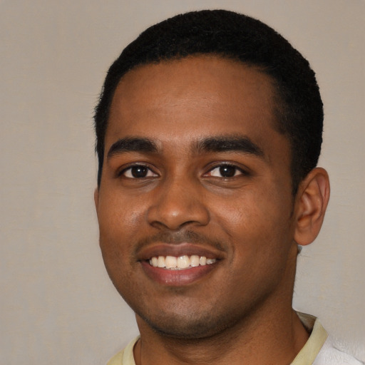 Joyful black young-adult male with short  black hair and brown eyes