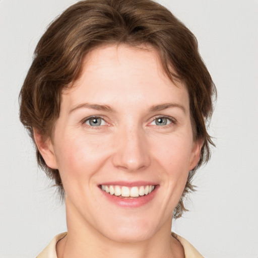 Joyful white young-adult female with medium  brown hair and blue eyes