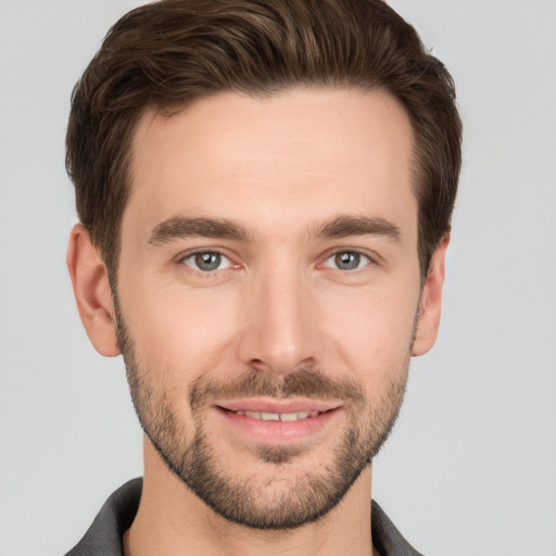 Joyful white young-adult male with short  brown hair and grey eyes