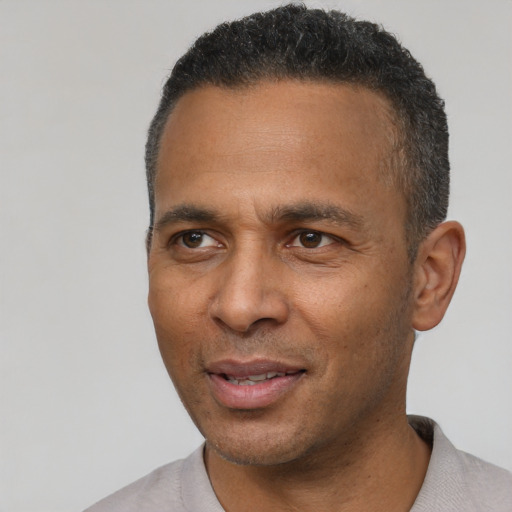 Joyful latino adult male with short  black hair and brown eyes