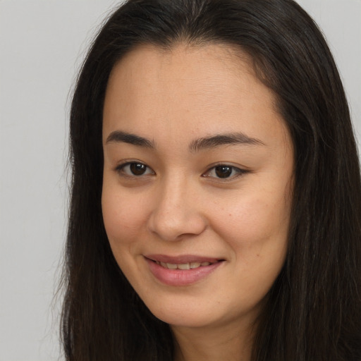 Joyful asian young-adult female with long  brown hair and brown eyes