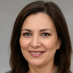 Joyful white adult female with long  brown hair and brown eyes