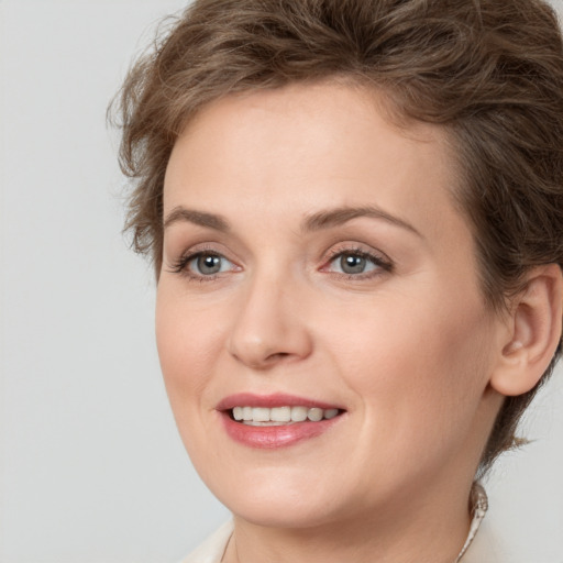 Joyful white young-adult female with medium  brown hair and grey eyes