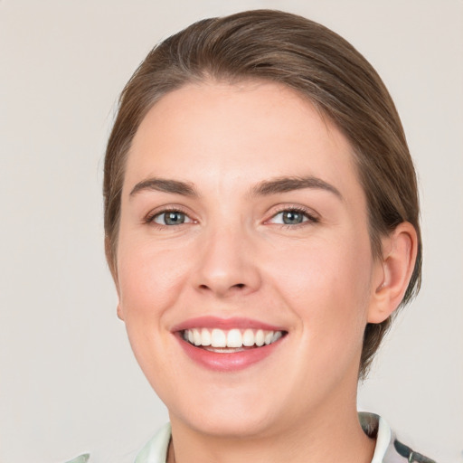 Joyful white young-adult female with medium  brown hair and grey eyes