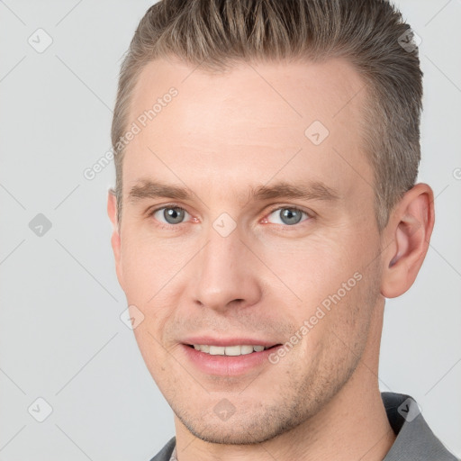 Joyful white adult male with short  brown hair and grey eyes