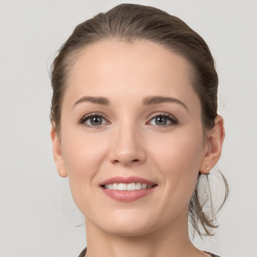 Joyful white young-adult female with medium  brown hair and grey eyes