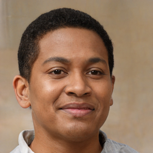 Joyful latino young-adult male with short  brown hair and brown eyes